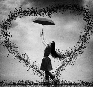Black and white image of a woman holding an umbrella